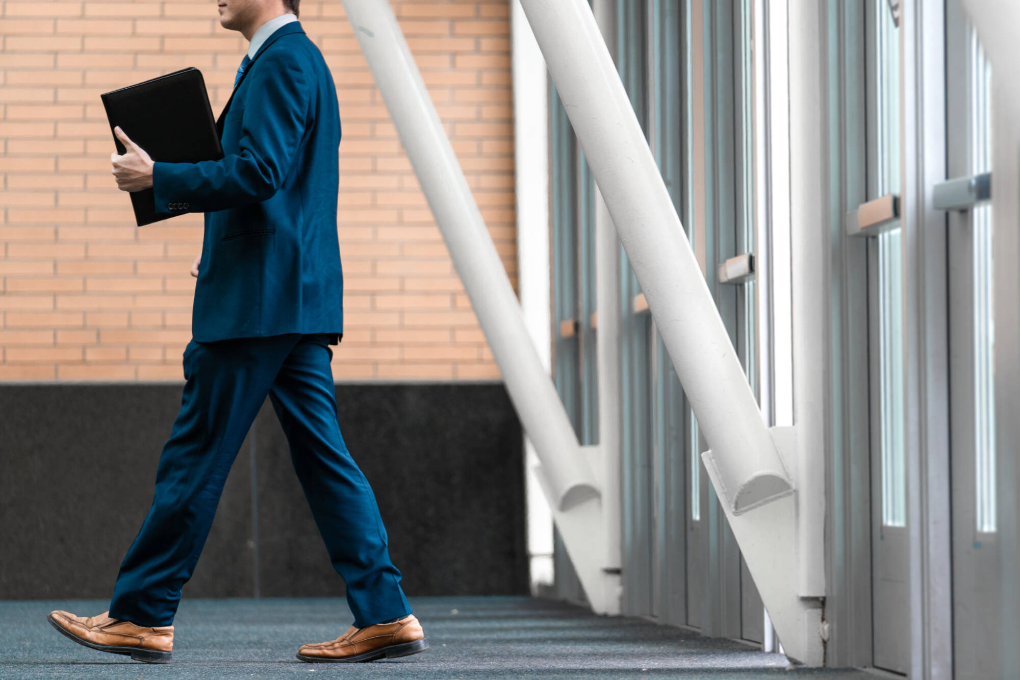 Student in a suit walking with their resume